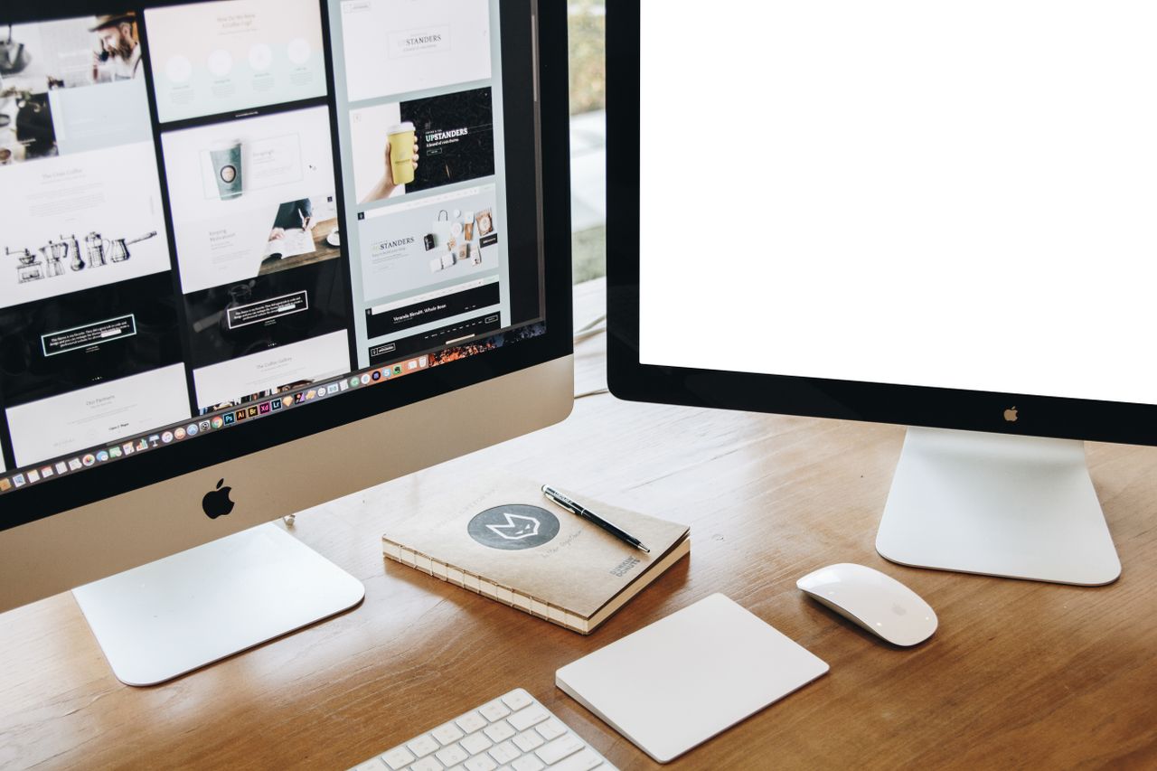 creative High-angle view of a stylish work desk featuring dual monitors, keyboard, mouse, and modern accessories.
