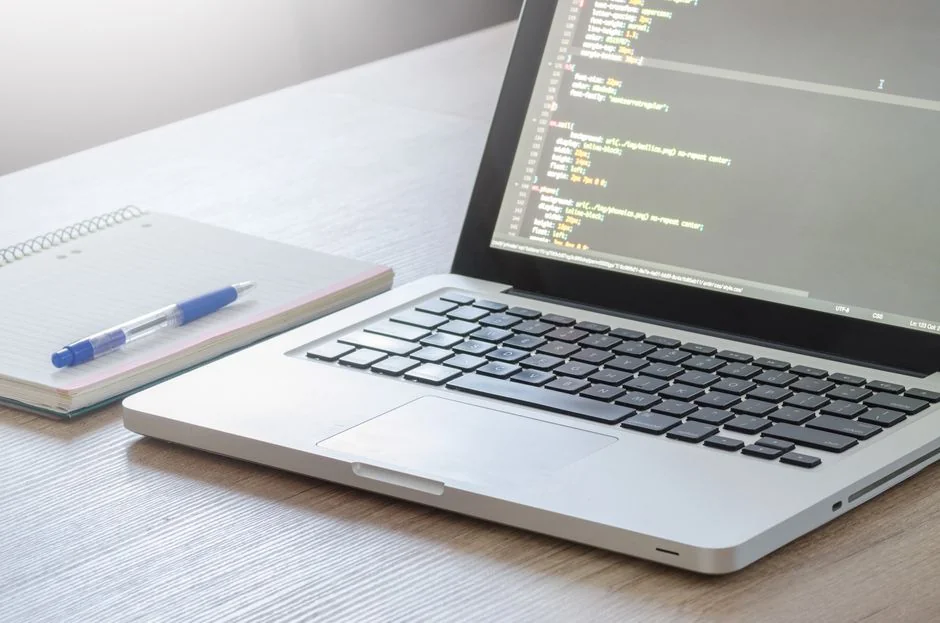 A man working on web design in a home office setup with dual monitors.